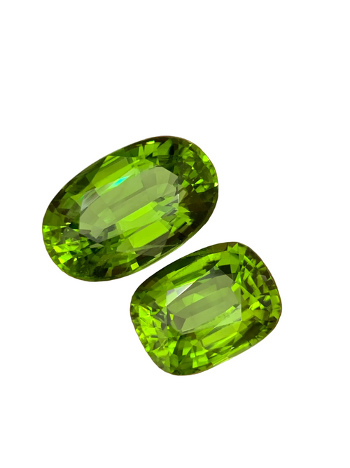 Two green Loose Peridots gemstones held