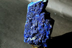 Natural Lazurite Specimen big size with deep blue and purple matrix, standing on a small display stand against a dark gray background.
