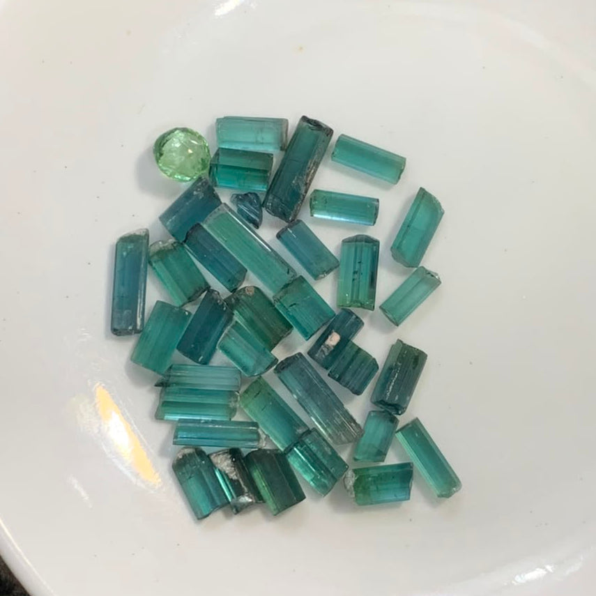 A pile of small rectangular green tourmaline crystals
