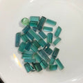 A pile of small rectangular green tourmaline crystals