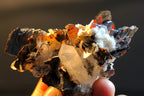 A close-up of holding a Brookite quartz mineral specimen with dark metallic-