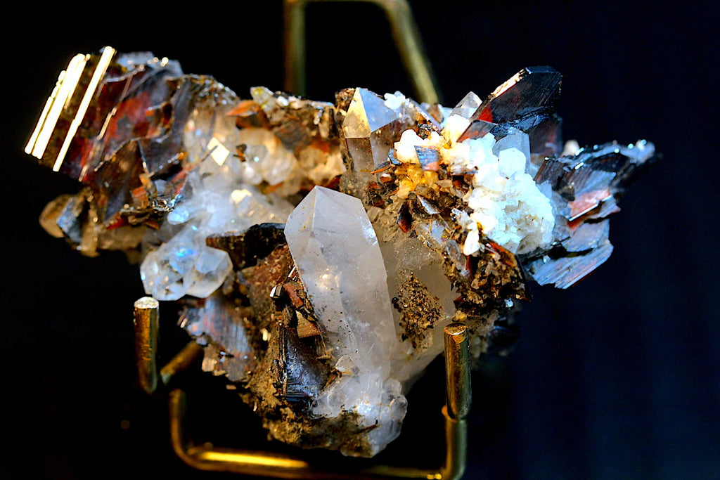 A mineral specimen featuring a large clear quartz crystal and brookite crystals