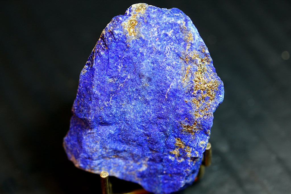 A rough blue lapis lazuli crystal specimen with prominent gold pyrite veins