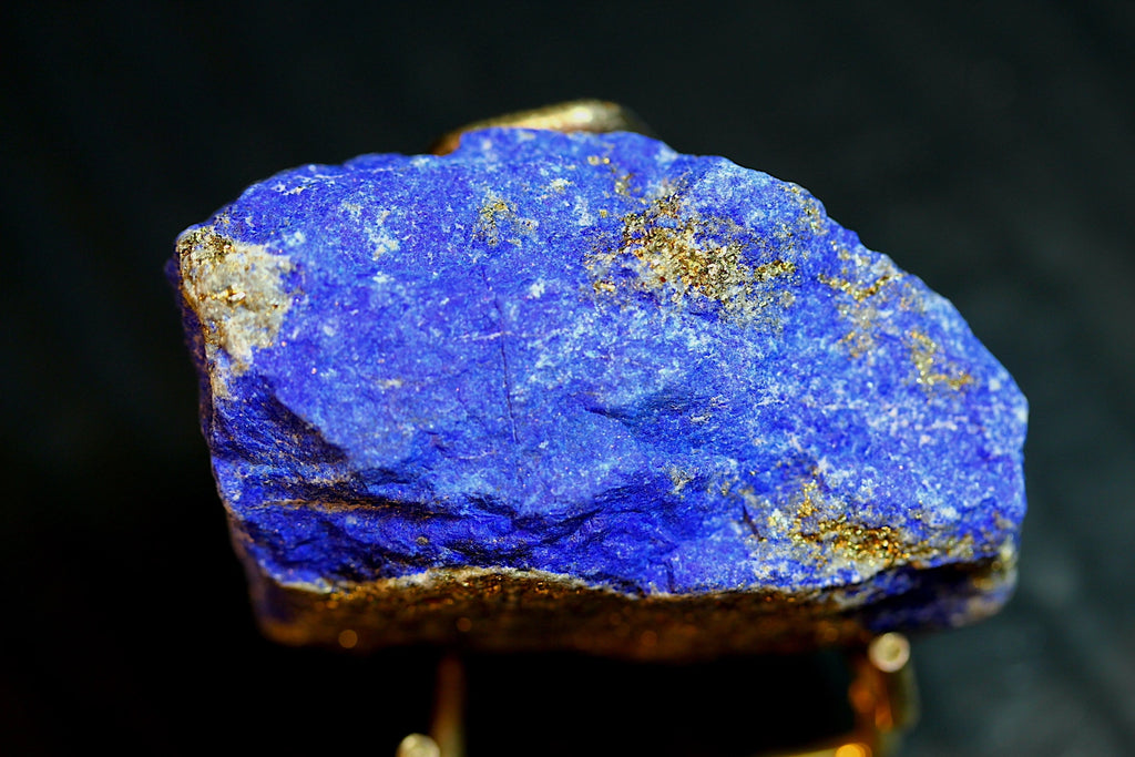 Uncut lapis lazuli crystal specimen with vibrant blue coloration and metallic gold pyrite inclusions