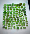 A collection of rough, uncut green peridot gemstones