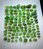 A collection of rough, uncut green peridot gemstones