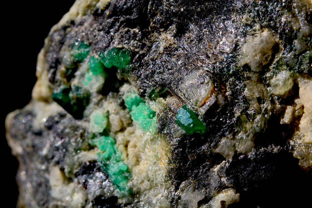 rough mineral specimen featuring bright green crystal clusters