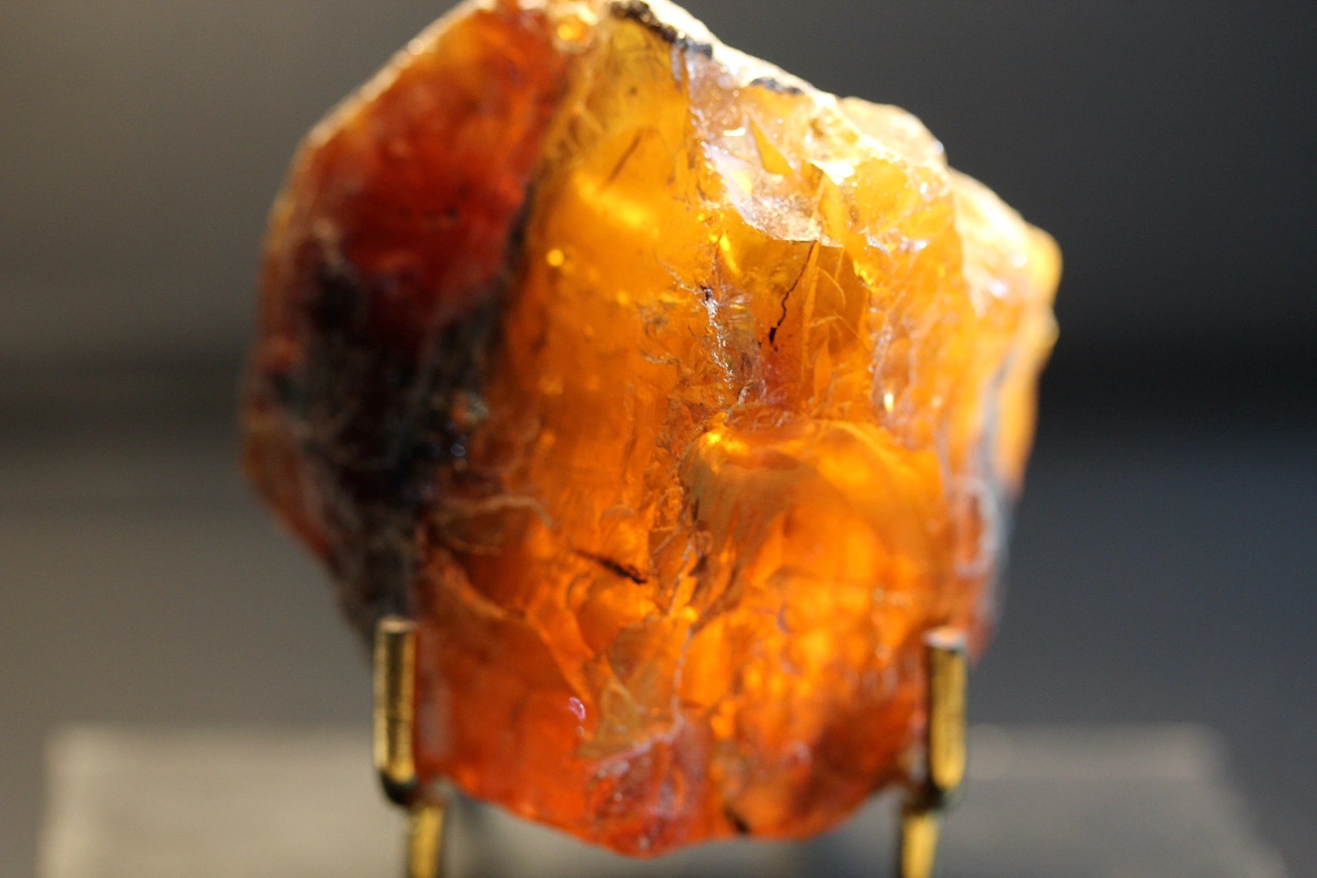 A raw, rough amber-colored gemstone or mineral specimen